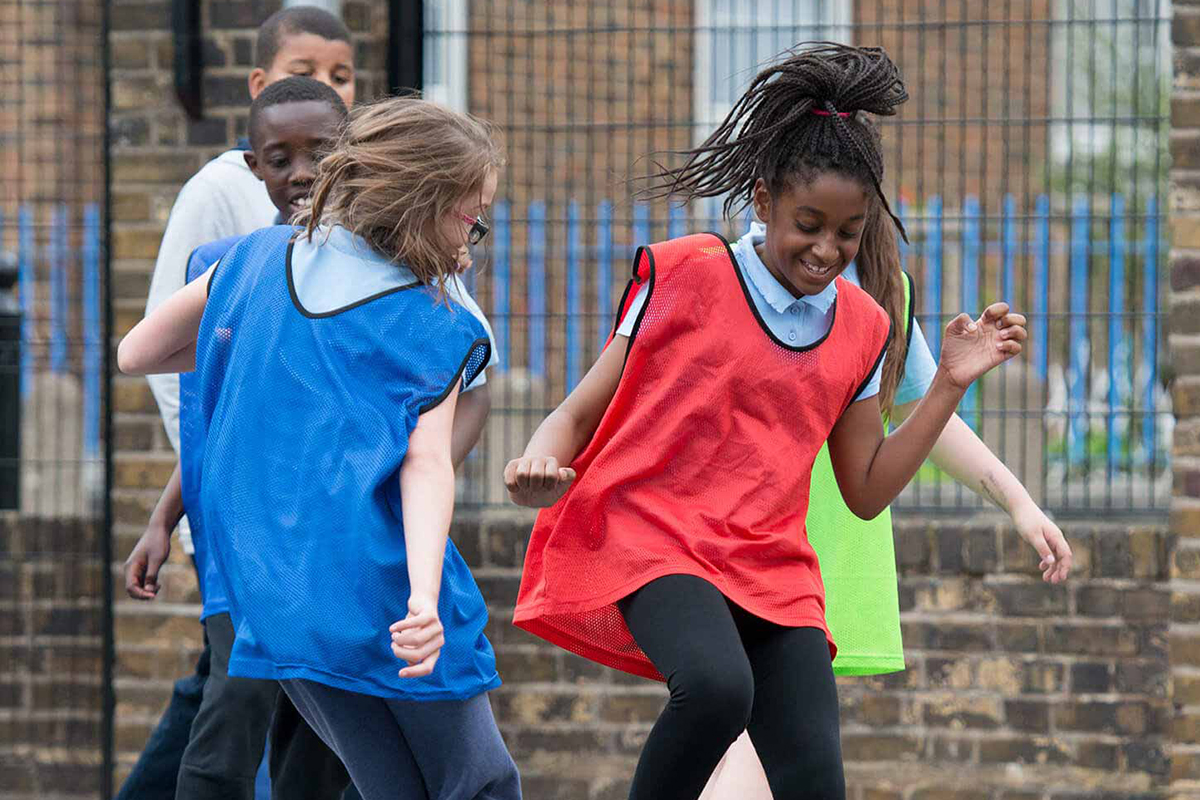 Girls playing football in the school yard.