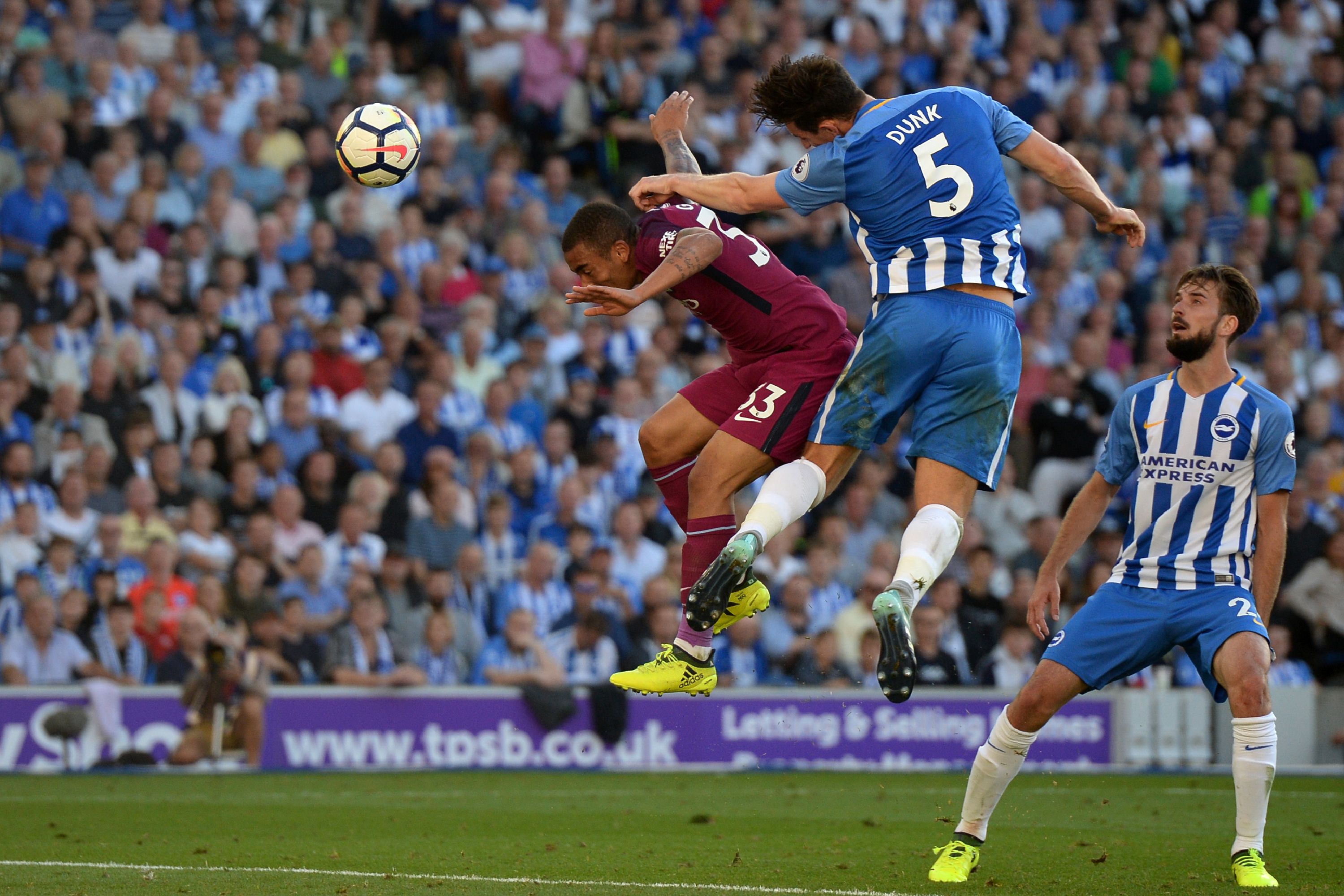 Brighton and Manchester City players jump for the ball